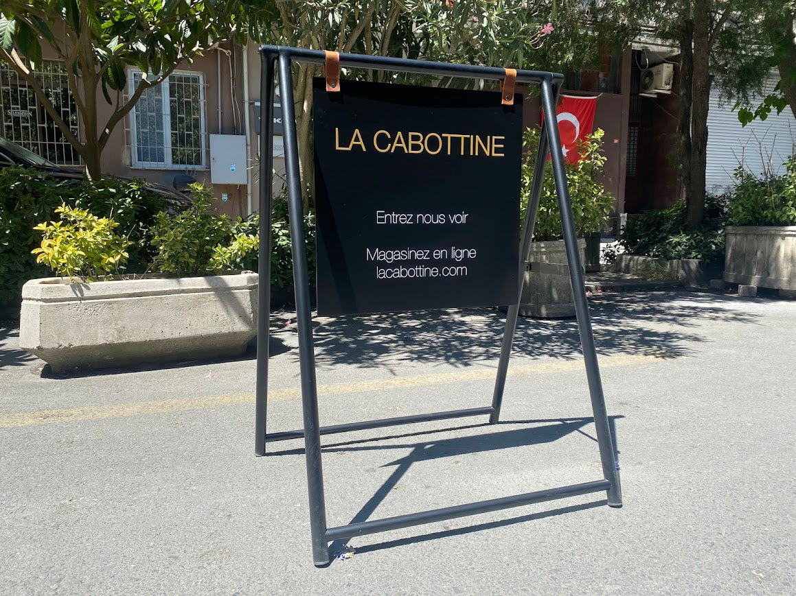 Metal gövdeli, çift taraflı kullanım sunan A Frame tabela açık halde.

