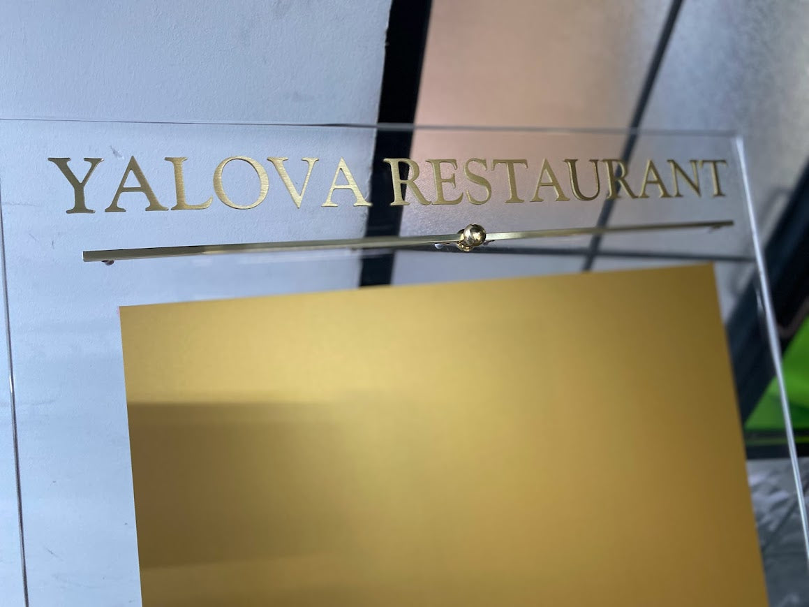 Kabartma harflerin altın renkli metal yüzeye nasıl işlendiğini gösteren detay fotoğrafı.