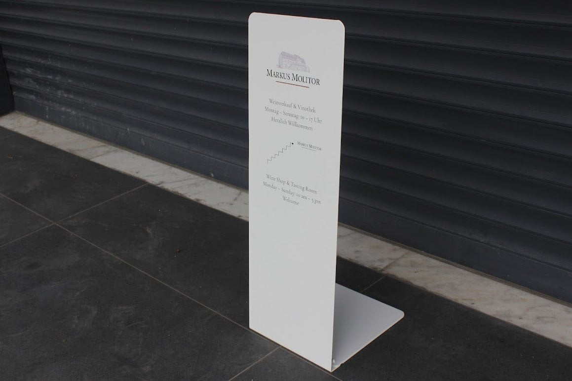 Metal gövdeli ayaklı reklam panosu dış mekânda kullanıma hazır şekilde konumlandırılmış.