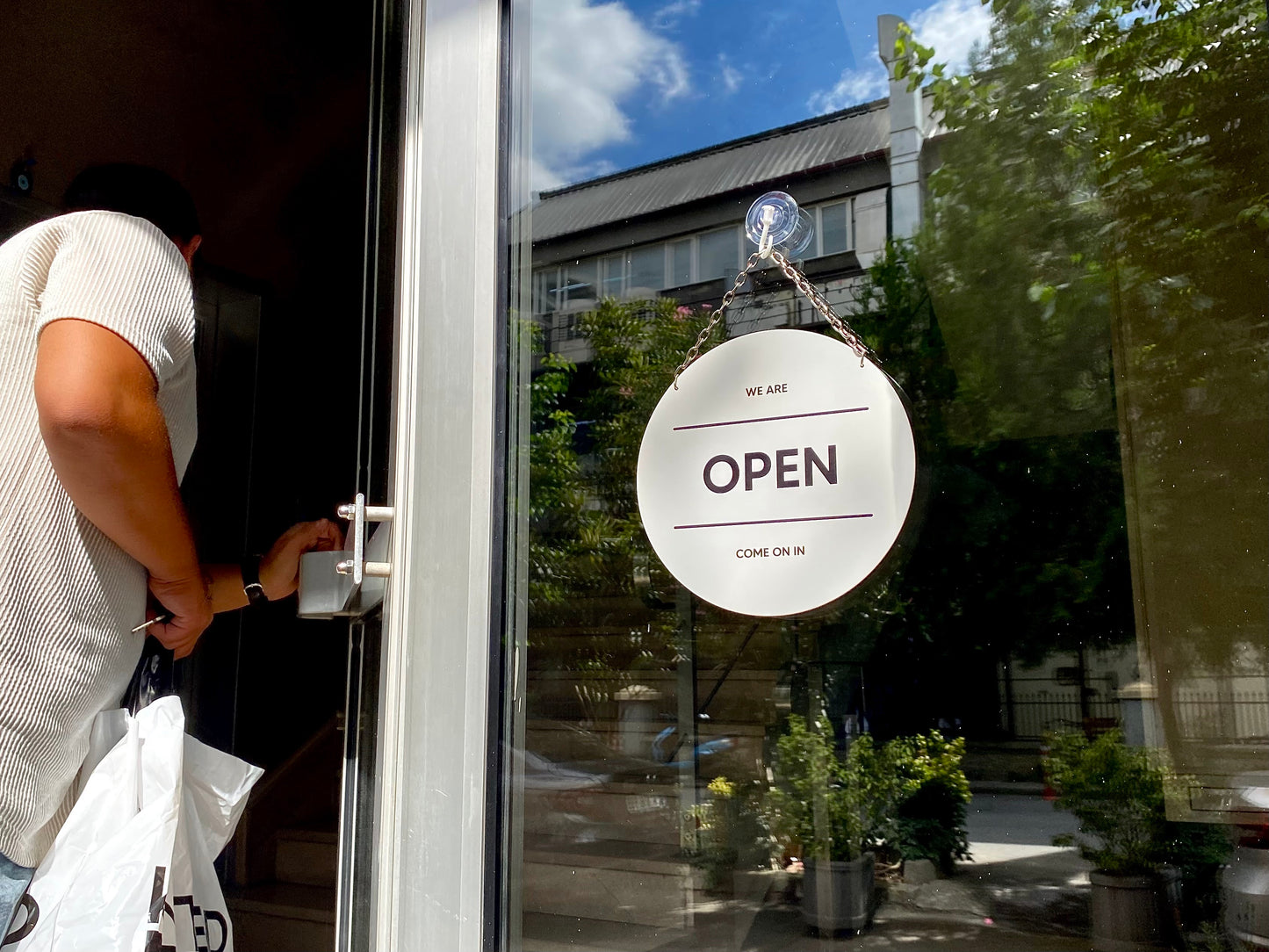 Beyaz renkli metal açık kapalı yazısı dükkan kapısında asılı