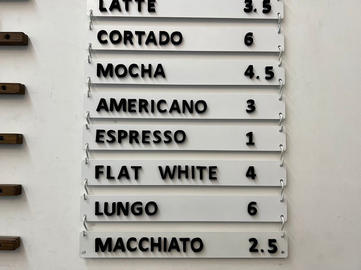 S-kancalar ile monte edilen beyaz manyetik harfli menü panosu.