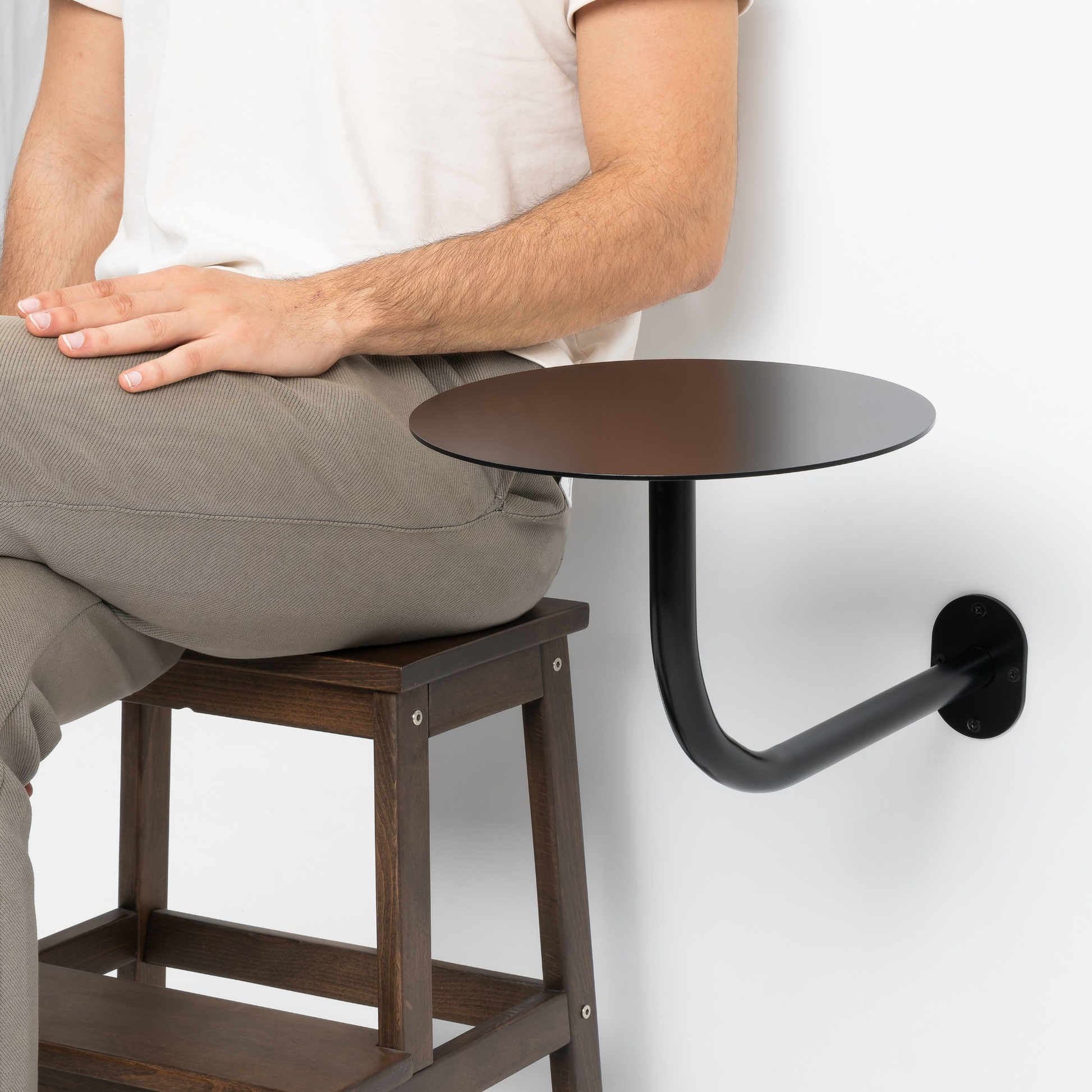 Dış mekanda kullanılan siyah metal duvar masası, kafe alanı için.