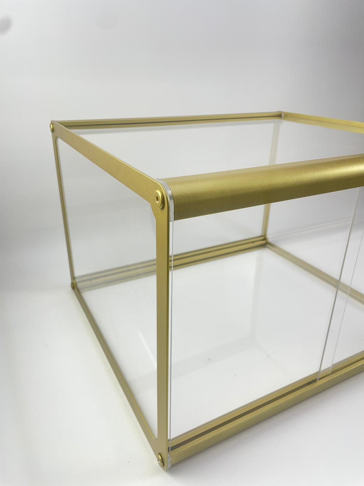 Gold metal çerçeveli cam sergileme vitrini köşe bağlantı detayı – şık ve modern tasarım teşhir standı.