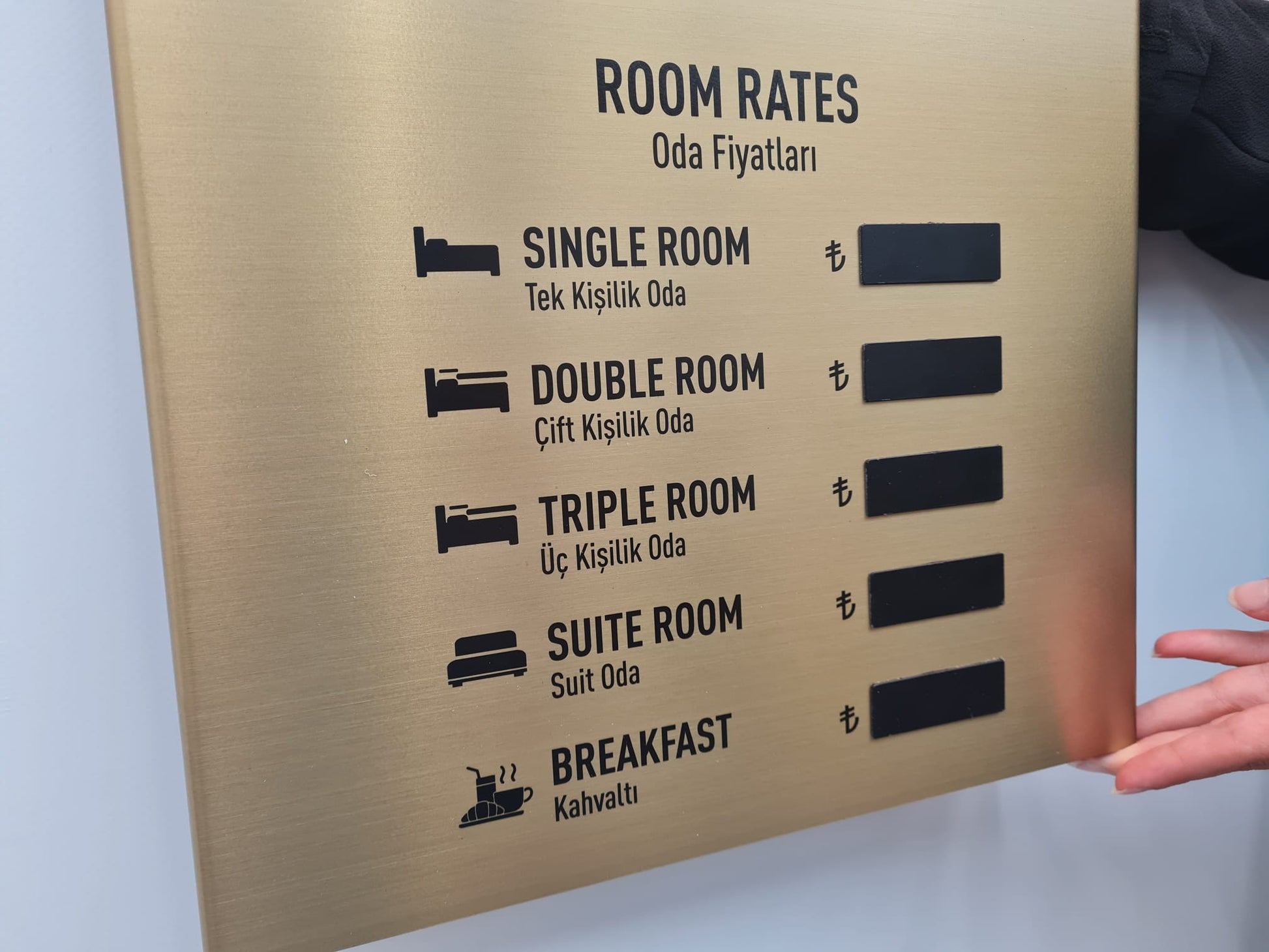 Gold renkli döviz panosu, otel lobisinde duvara monte edilmiş, şık ve prestijli görünüm.