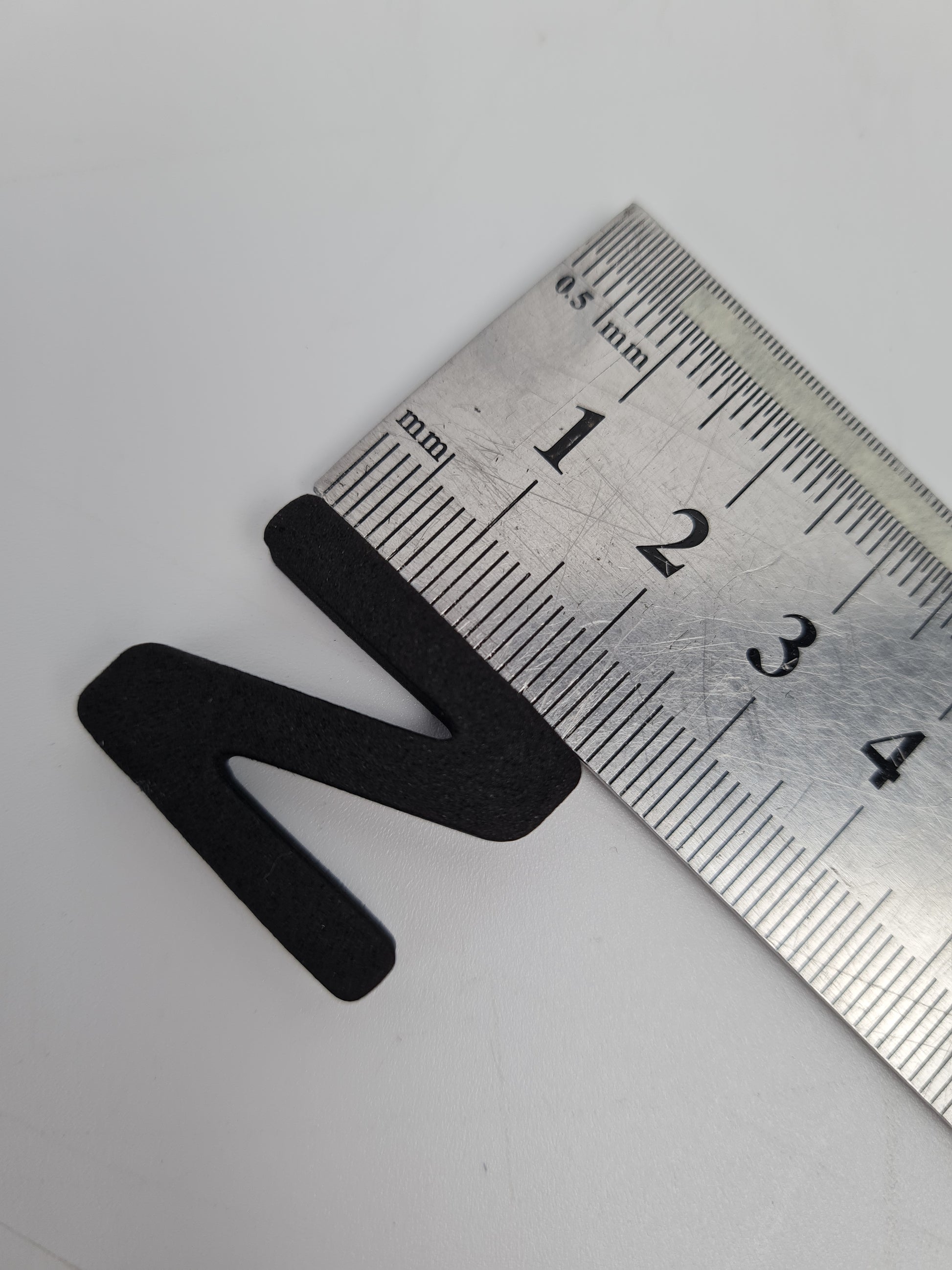 Mıknatıslı harflerin boyutları, cetvel ile karşılaştırılarak gösterilmiştir.