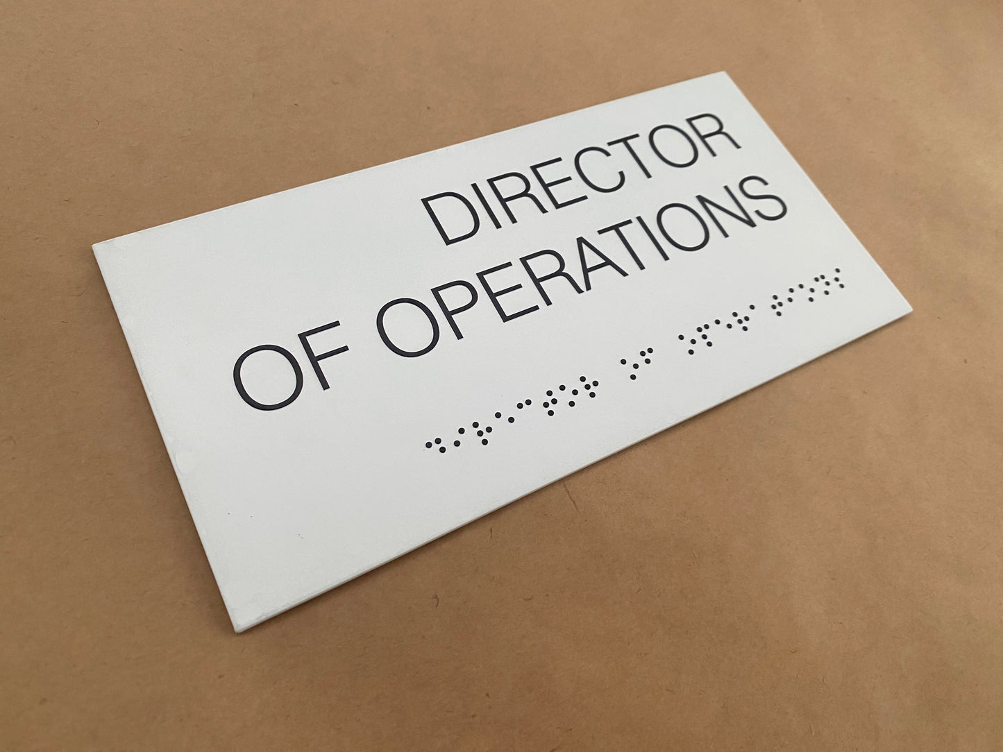 Kabartma Braille yazı ve sade tipografiye sahip şık ofis oda tabelası.