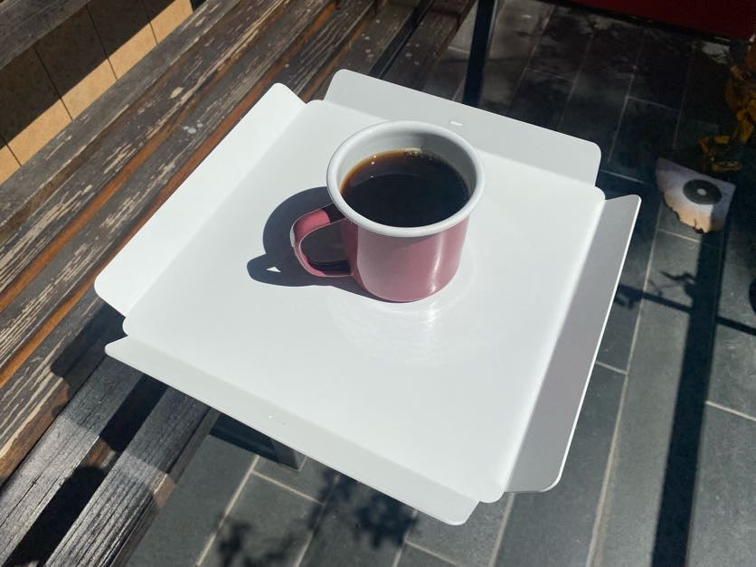 Üzerinde kahve bardakları bulunan beyaz metal servis tepsisi.