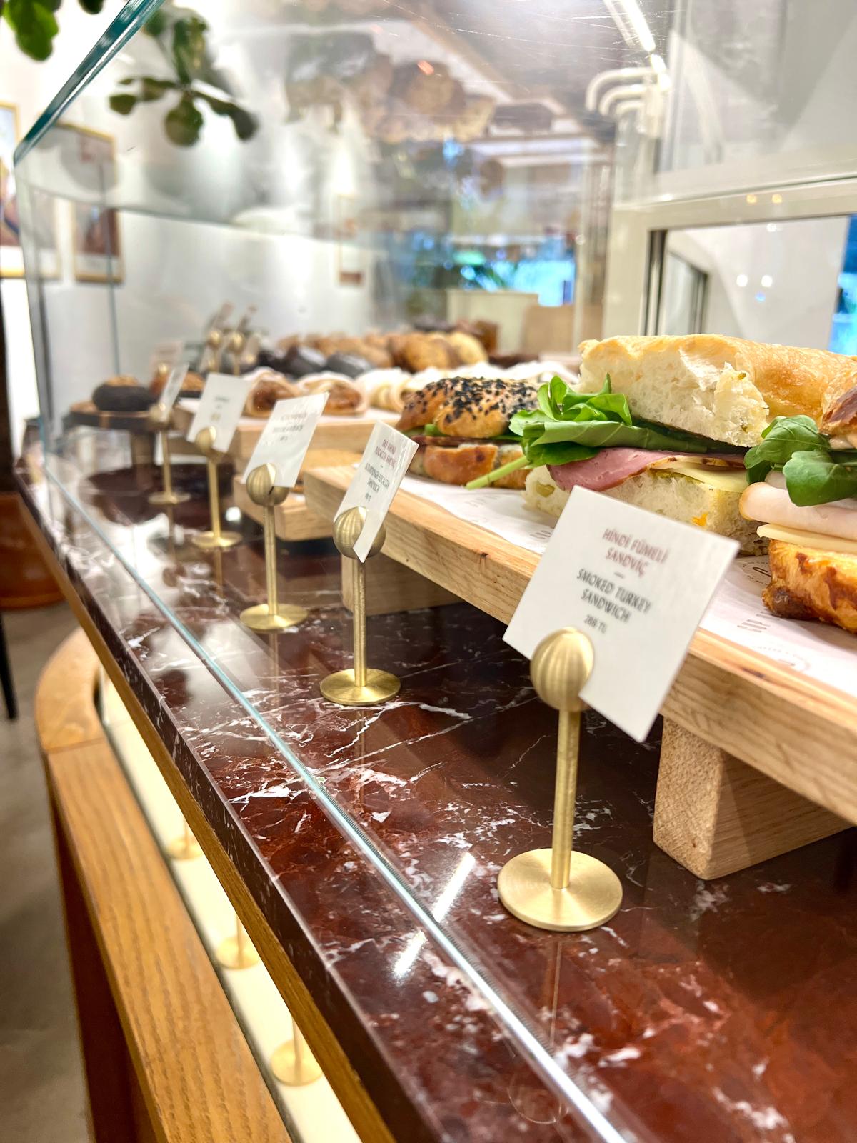 Büfe masasında şık sunum sağlayan pirinç kart tutucu detayı.