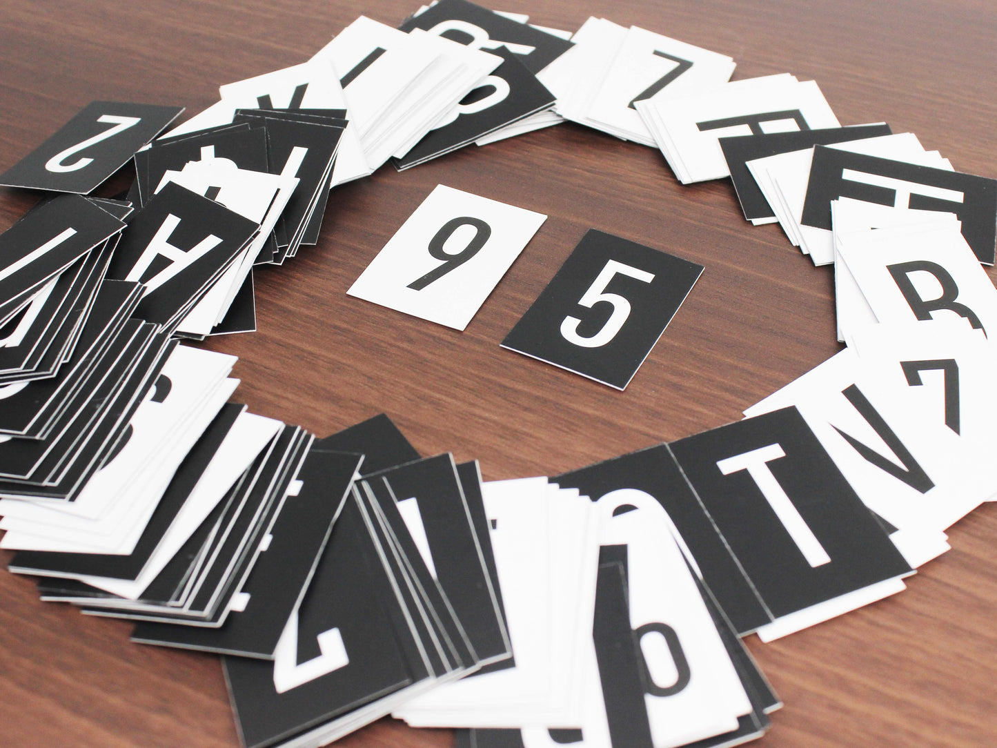 Siyah ve beyaz yüzeyli selofan kaplı karton harf seti.