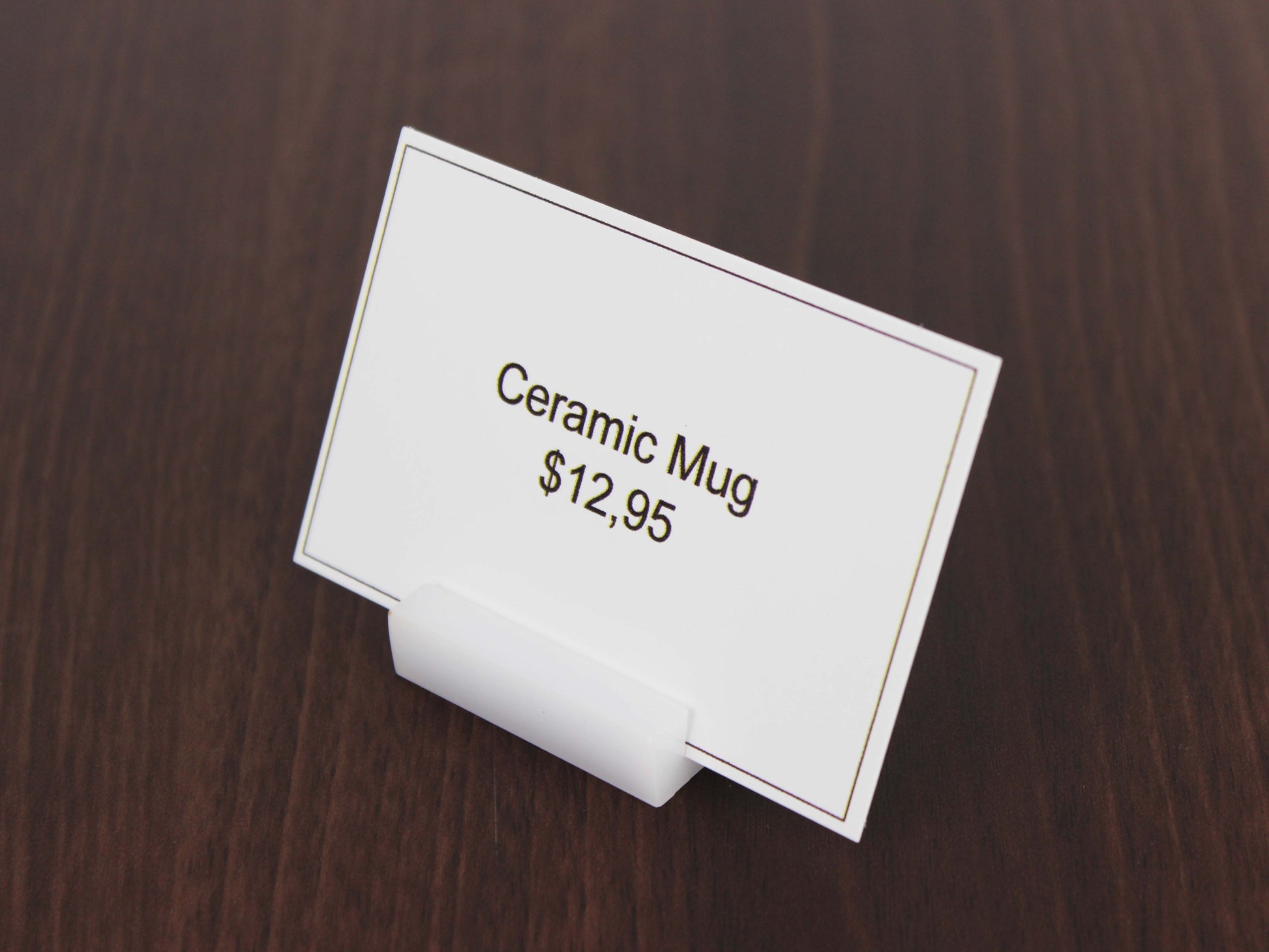 Masa üstü kartvizit standı, akrilik malzeme ve sade duruş.