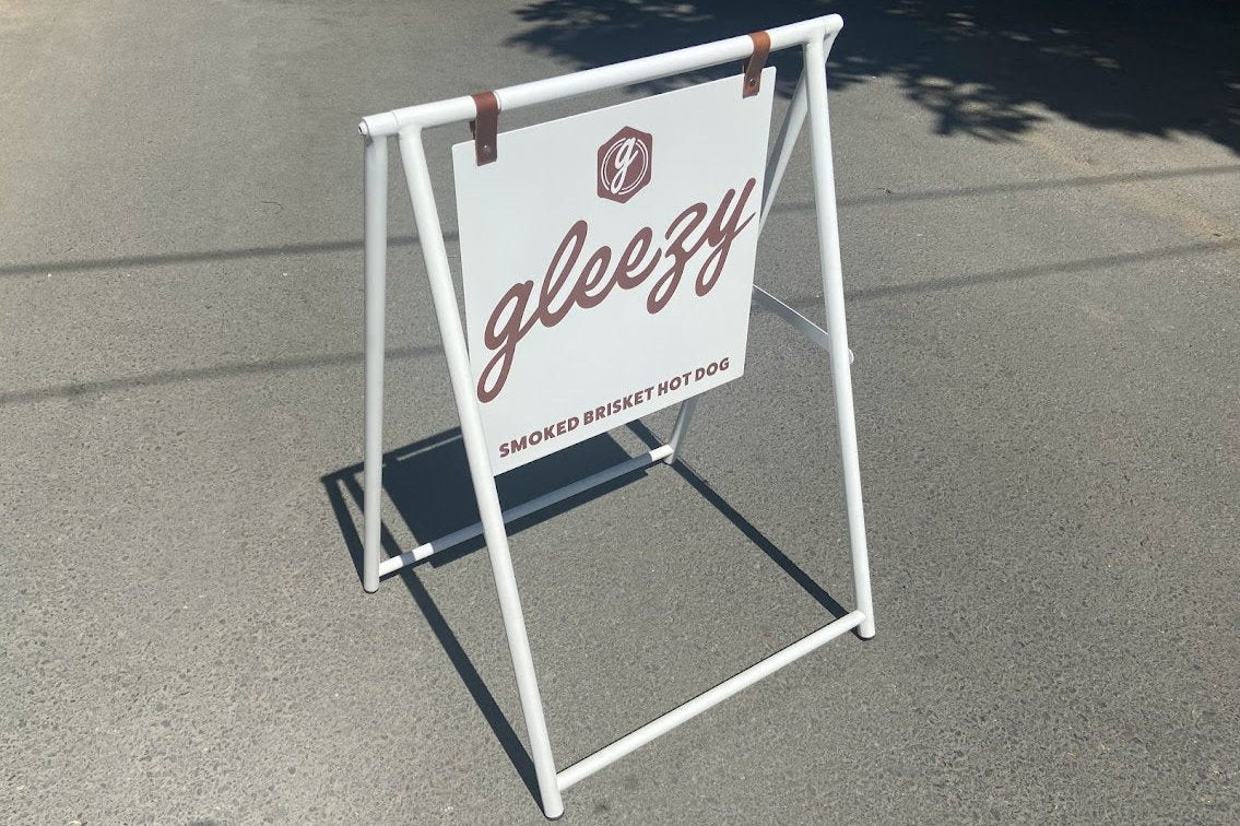 Katlanabilir, metal gövdeli, deri kayışlı A Frame tabela ön cepheden görünüm.