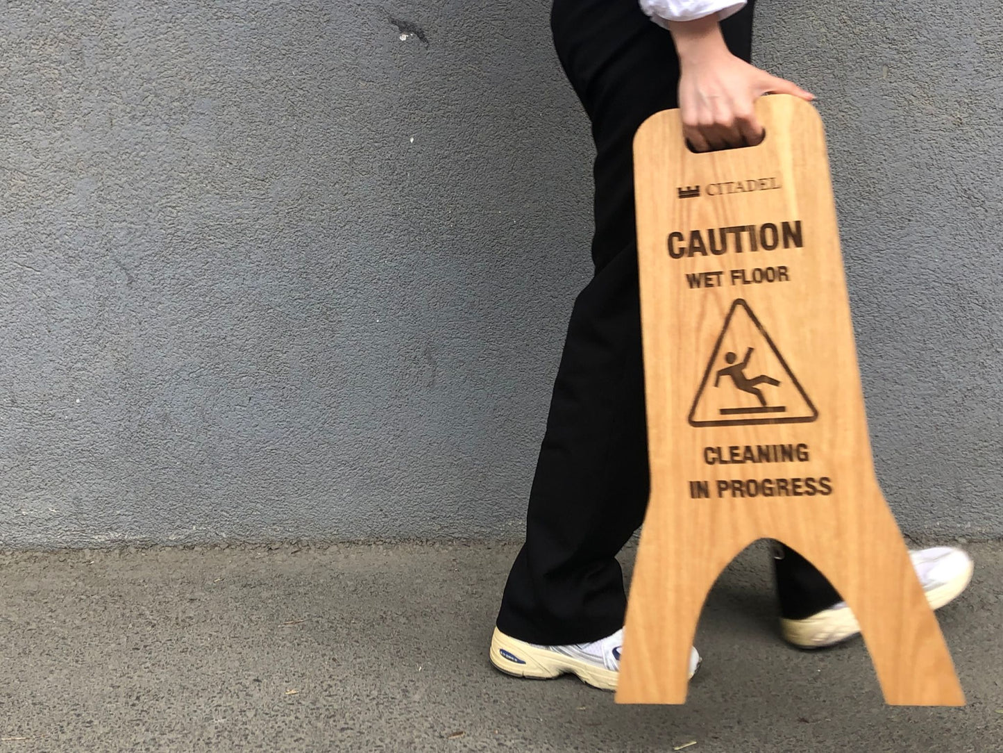 Kaygan zemin uyarısı taşıyan katlanabilir ahşap tabela.