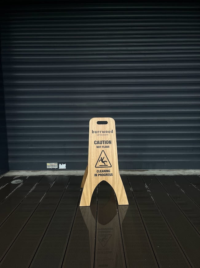 “Caution Wet Floor” uyarısı taşıyan ahşap tabela modeli.