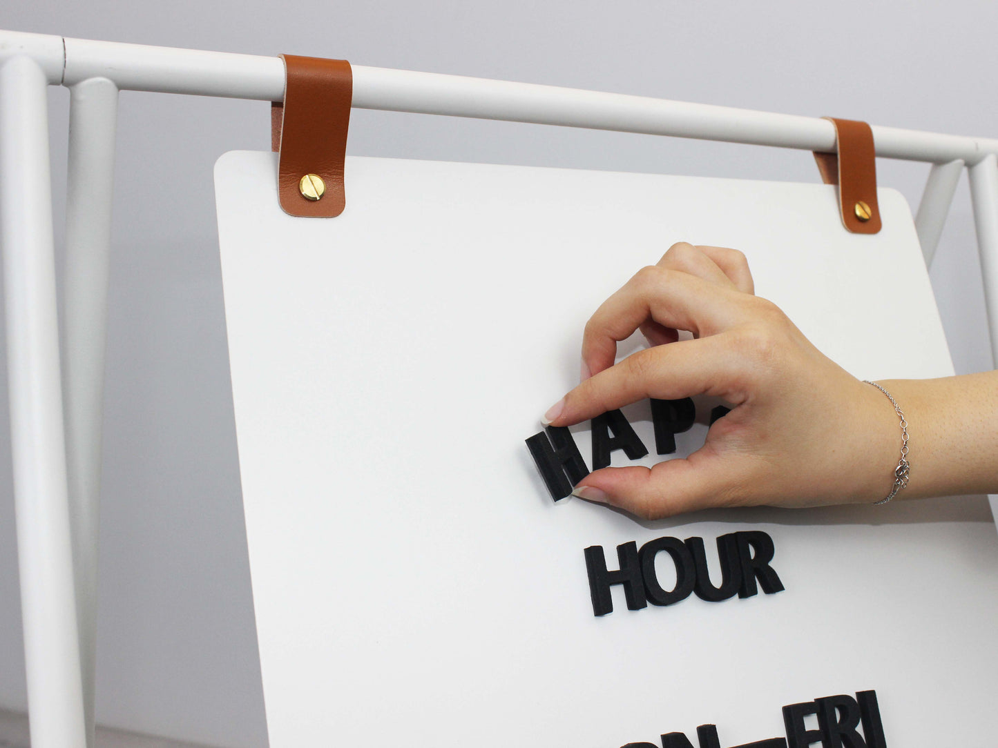 Manyetik harflerle mesaj oluşturulmuş kaldırım tabelası örneği.