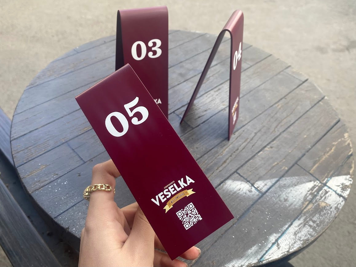 V formundaki masaüstü metal tabela, QR kod sayesinde dijital menü erişimi sağlar.