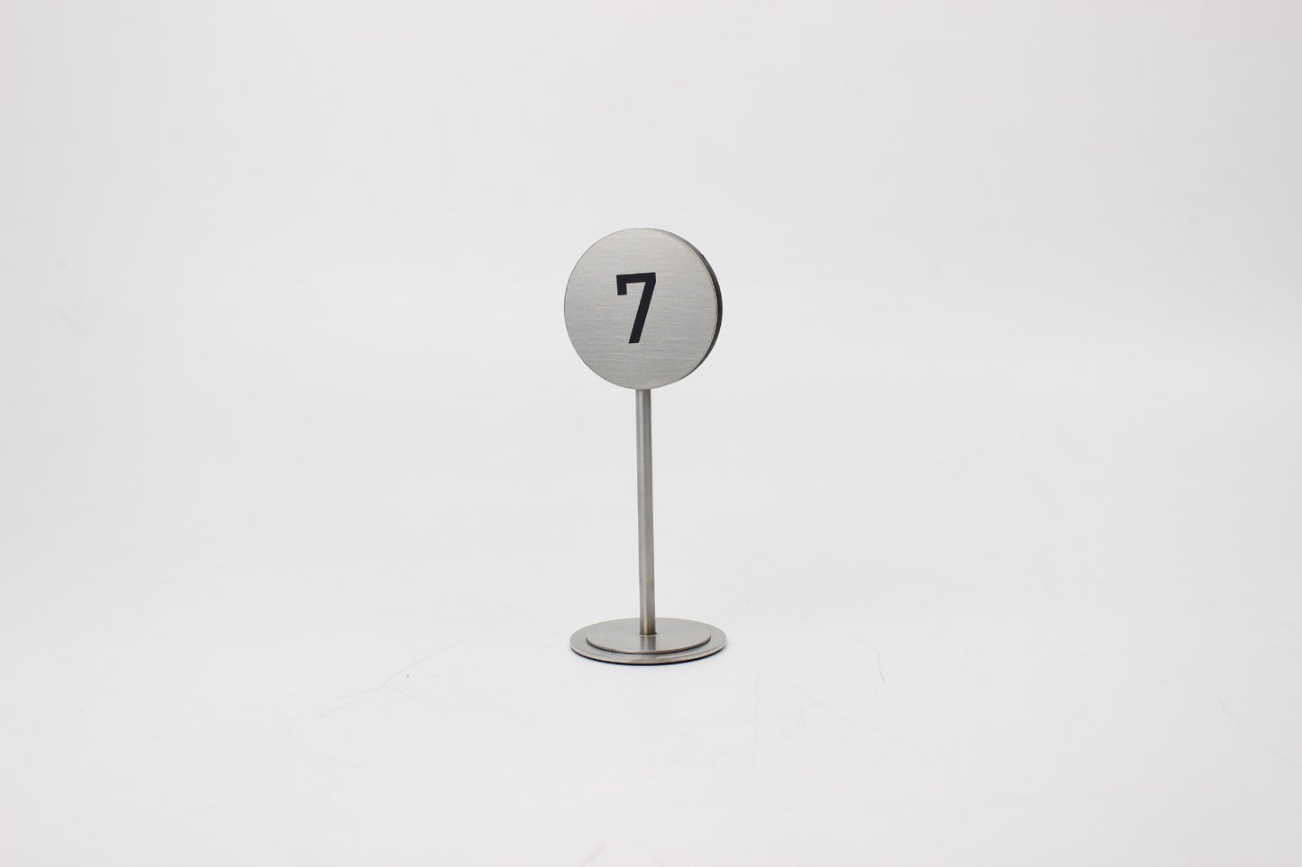 Masa üzerinde görünür şekilde konumlandırılmış metal numaratör.
