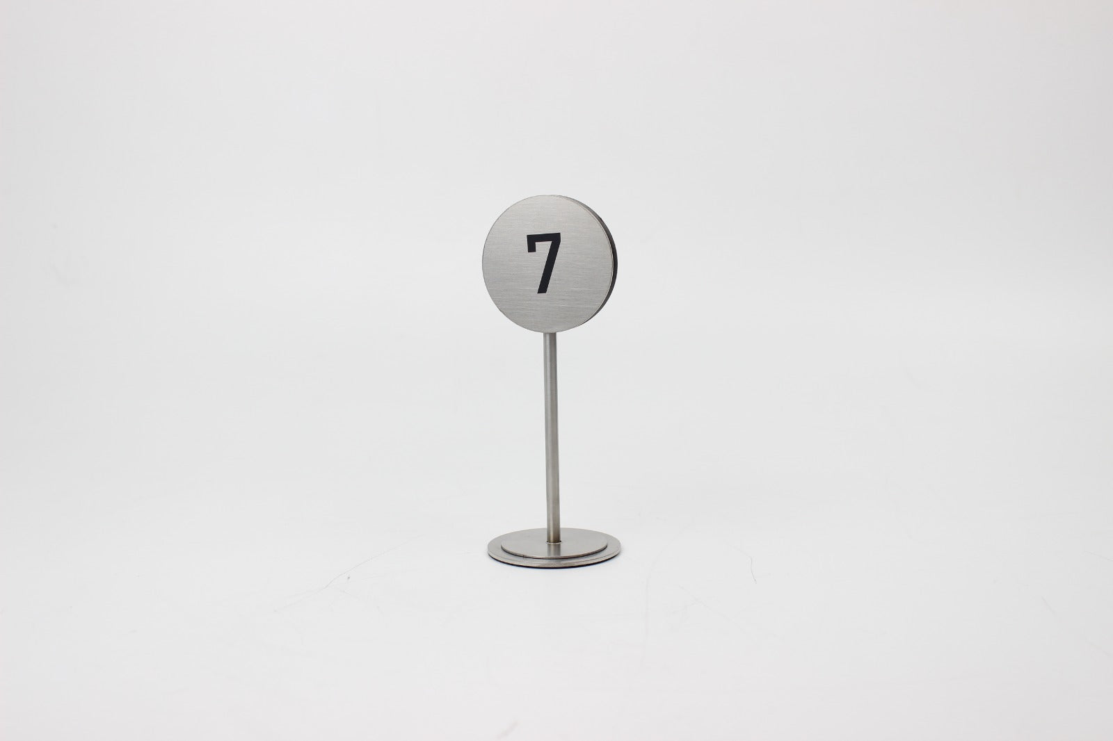 Masa üzerinde görünür şekilde konumlandırılmış metal numaratör.