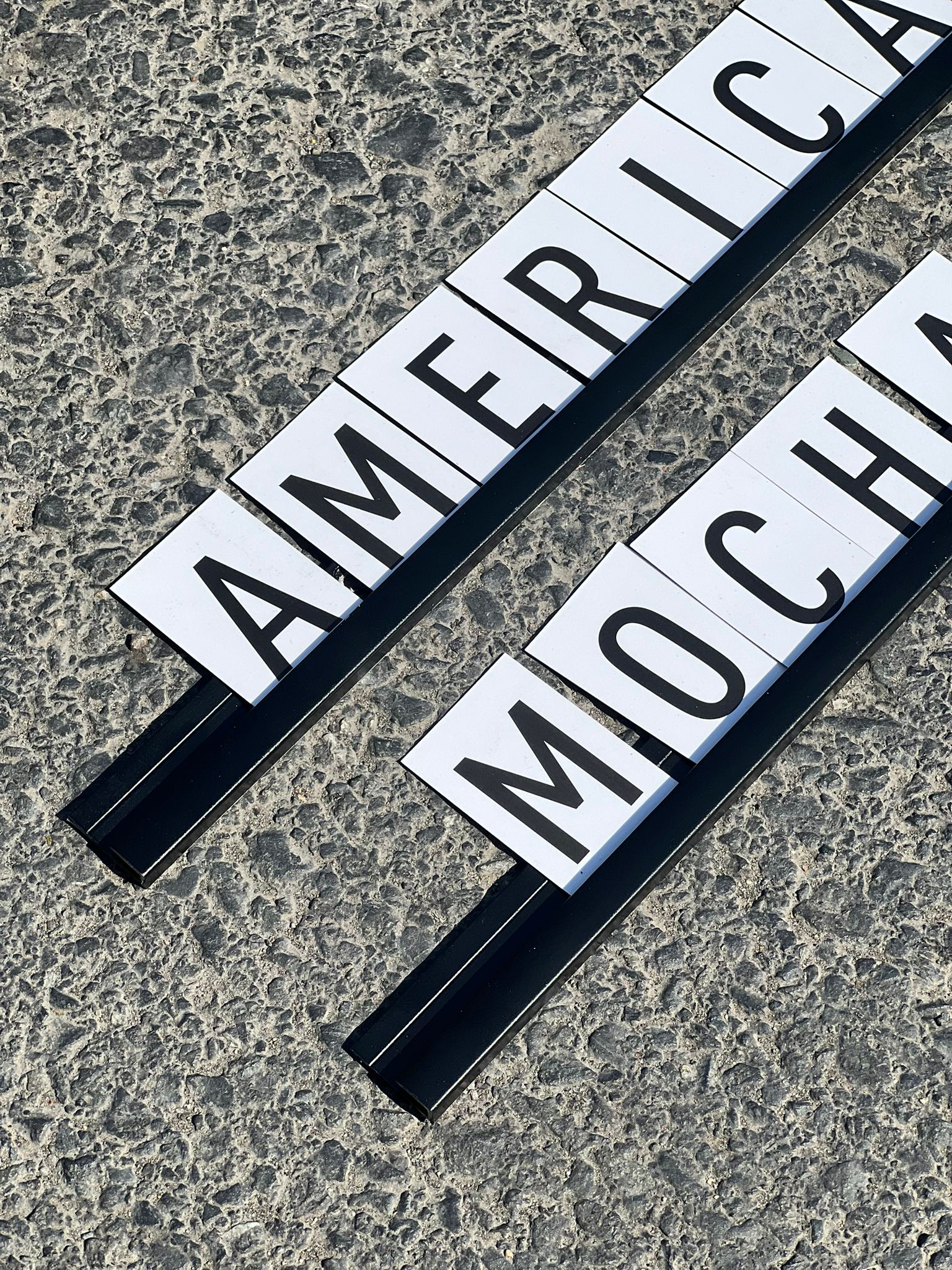 Raylı sistemle monte edilmiş siyah-beyaz harfli fiyat ve menü panosu.