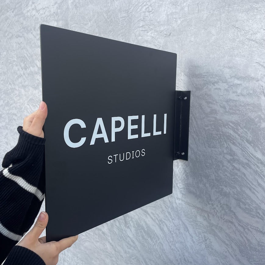 Modern tasarımlı kare tabela, dış mekan duvarına monte edilmiş.