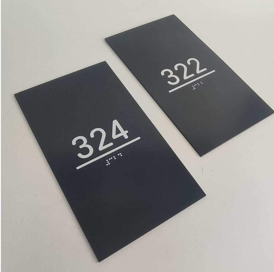 Otel kapısının yanına monte edilmiş Braille alfabeli metal kapı numarası tabelası