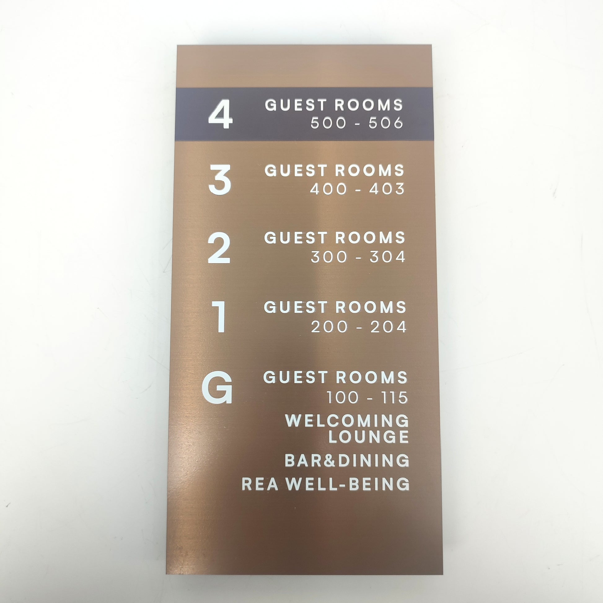Bronz renkli otel yönlendirme tabelası, zarif ve okunabilir tipografiyle.