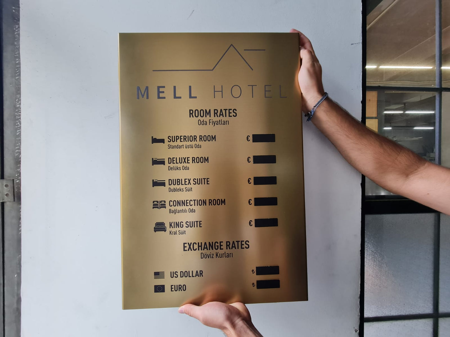 Gold kaplama lüks fiyat panosu, otel lobi duvarında konumlandırılmış.