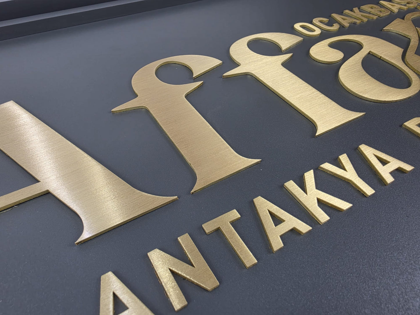 Pirinç kabartma harf detay görünümü metal tabela yüzeyinde yakın plan