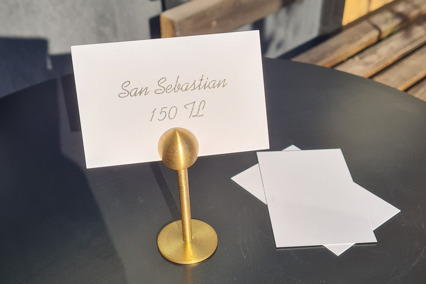 Ayaklı yapısıyla dikkat çeken pirinç kart tutucu, kolayca görülebilir.