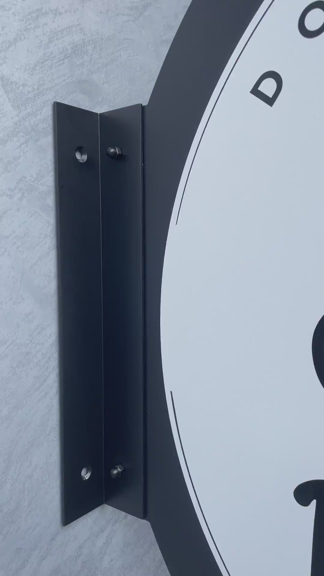 Duvara monte edilen yuvarlak metal tabelanın çift taraflı kullanım özelliği, renk seçenekleri ve montaj detaylarıyla tanıtıldığı ürün videosu.