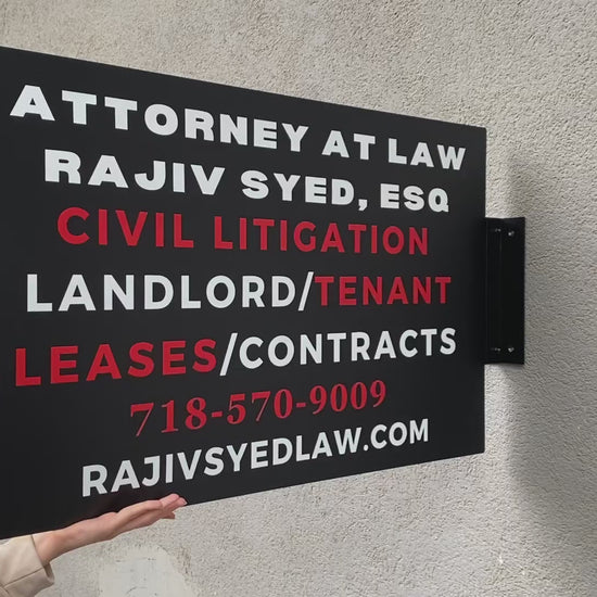 Duvar rengiyle uyum sağlayan mat siyah dikdörtgen tabela örneği.

