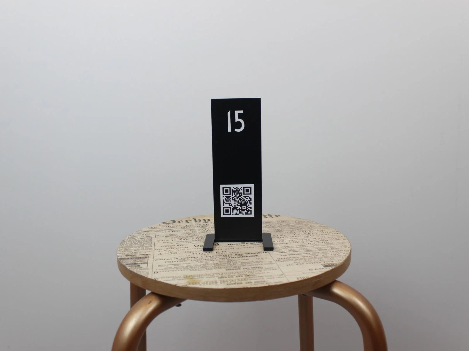 Siyah metal gövdesi ile işletme logosu baskılı QR kod standı.