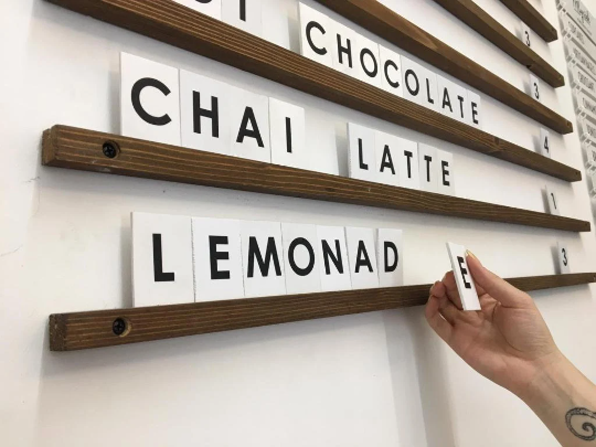 Duvara monte edilebilen beyaz PVC harfli ahşap menü panosu.
