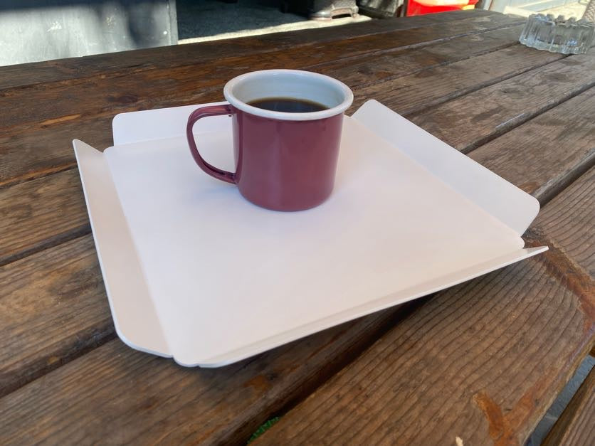 Restoranda yemek ve içecek taşımada kullanılan beyaz metal servis tepsisi.