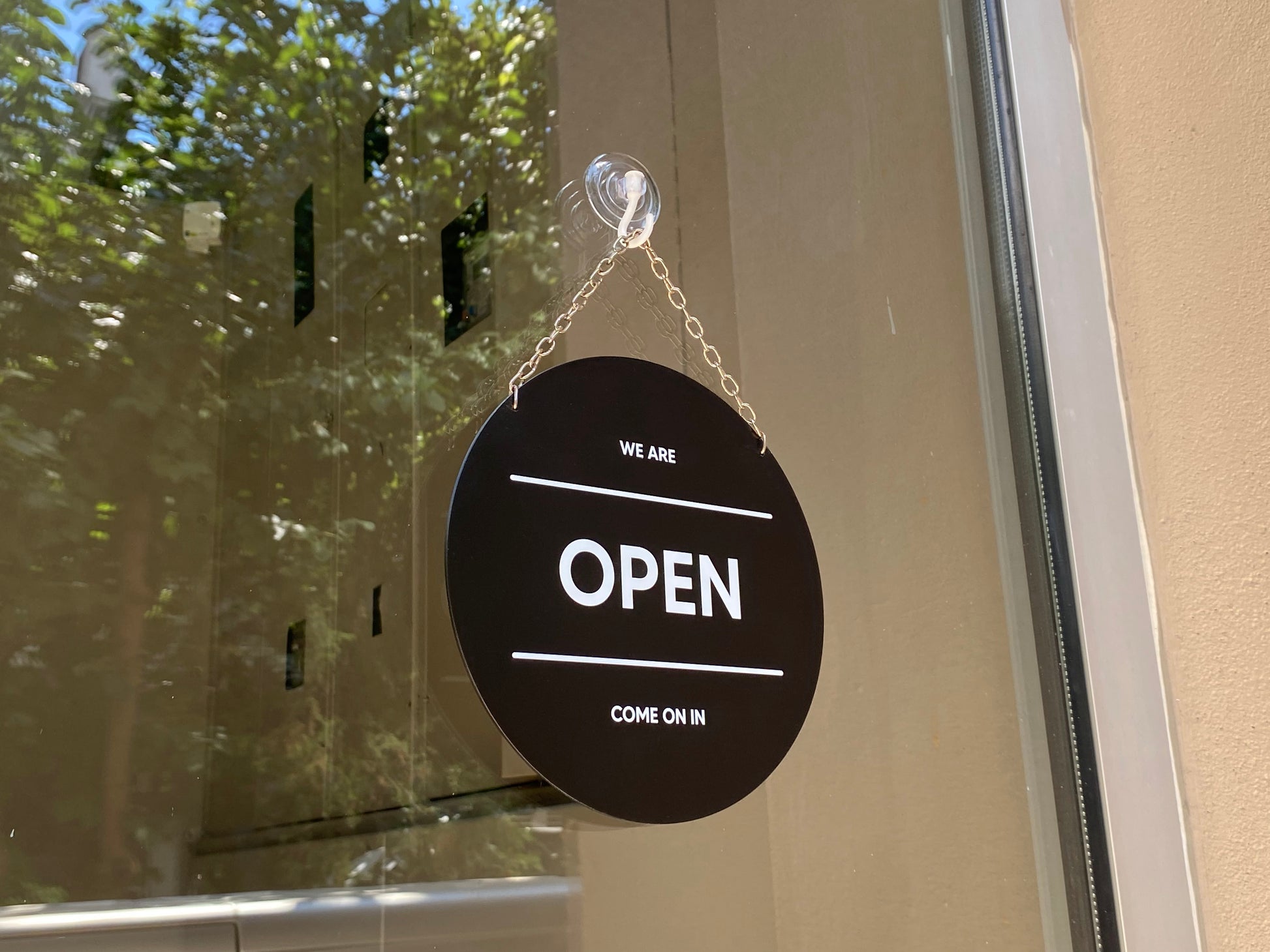 Dükkan giriş kapısında yuvarlak metal open closed tabelası