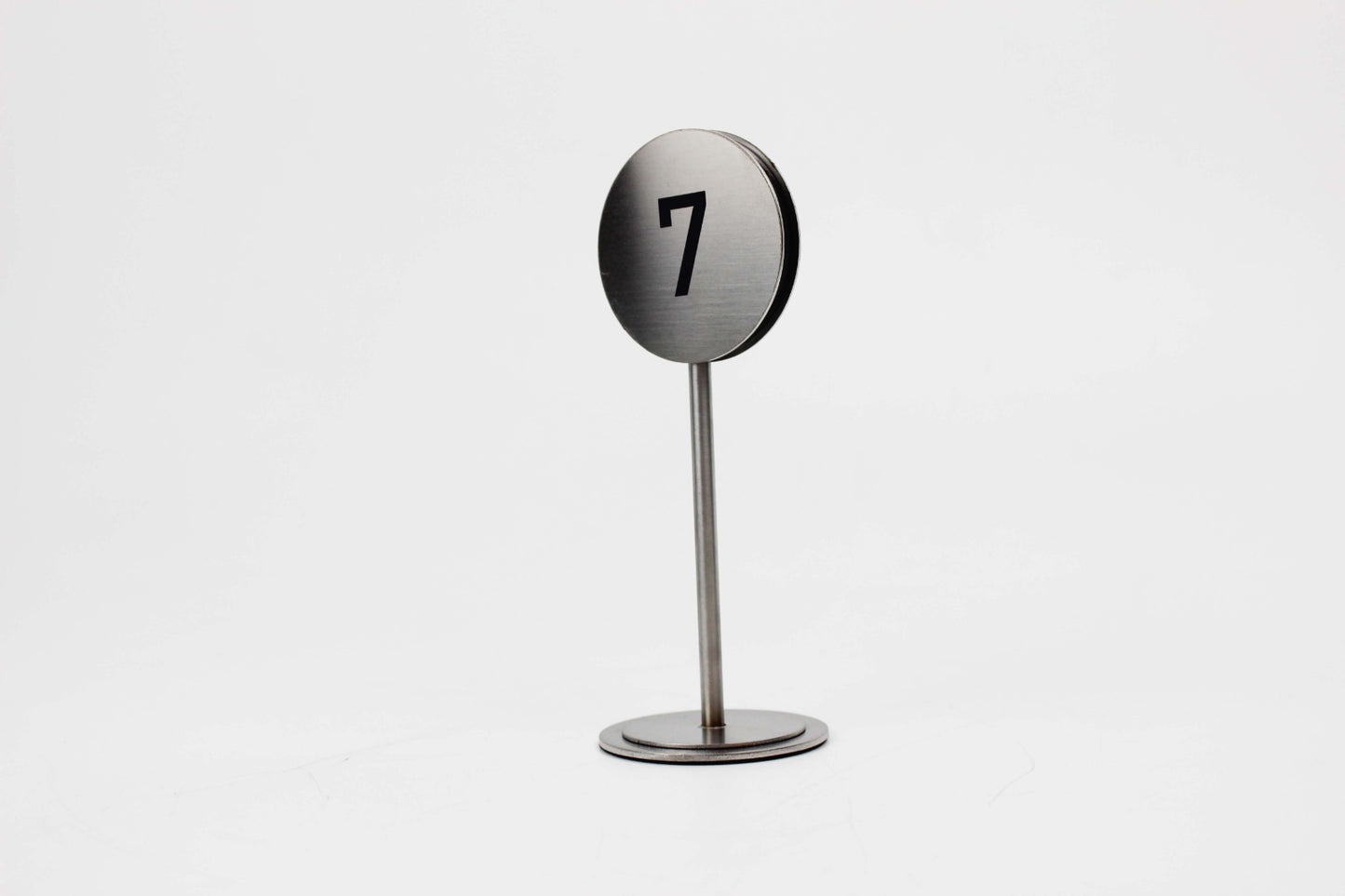 Minimal tasarıma sahip zarif metal masa numaratörü.

