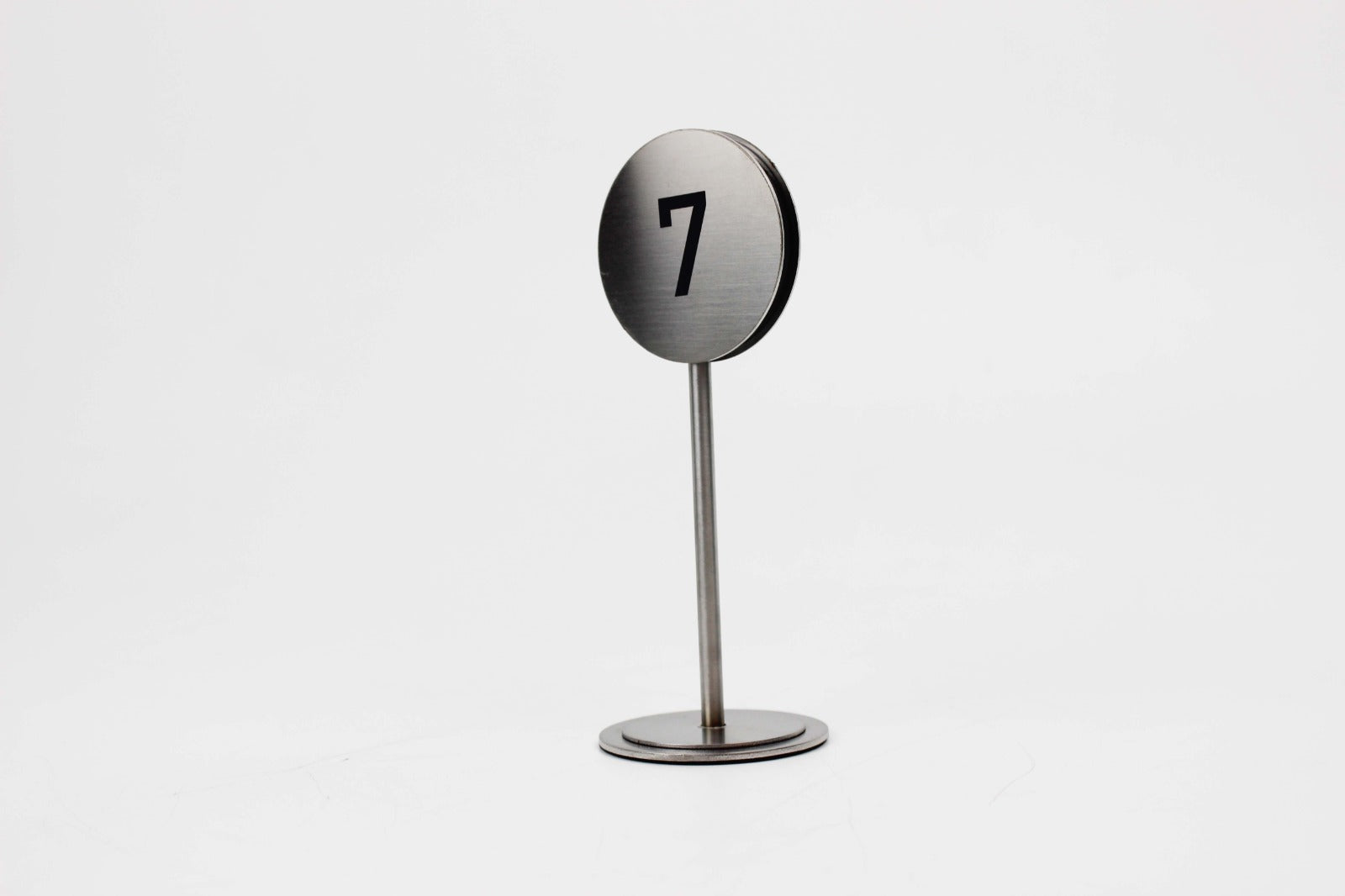 Minimal tasarıma sahip zarif metal masa numaratörü.

