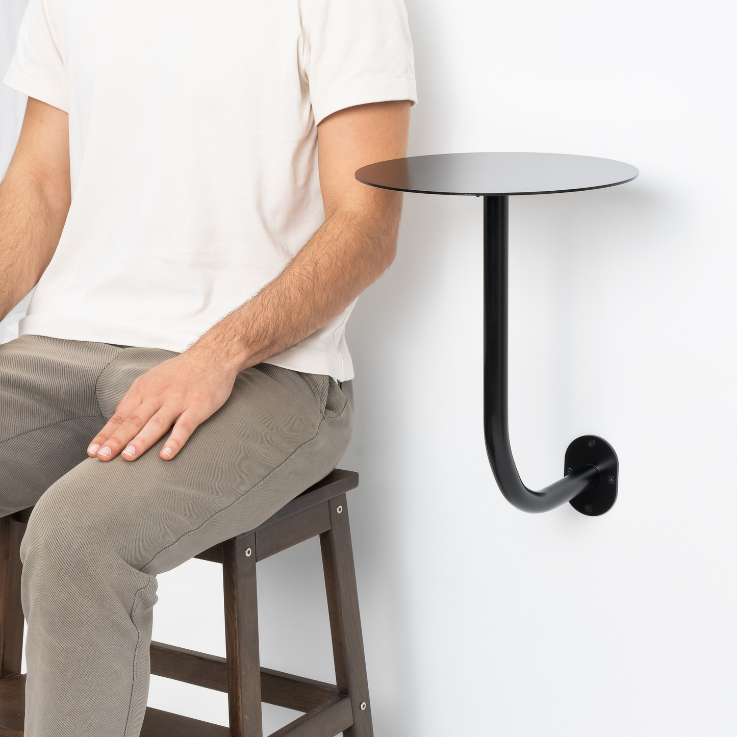 Cafe duvarına monte edilmiş siyah yuvarlak masa, kahve molası alanı.