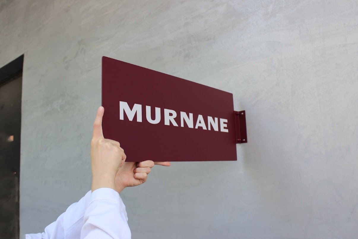 Özel renge boyanmış dikdörtgen formda metal tabela, güneş ışığında parlayan yüzey detayıyla.