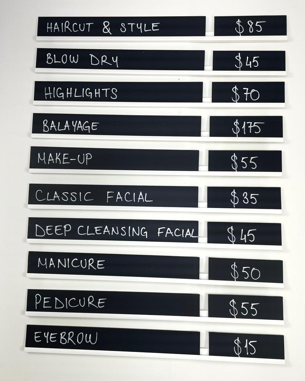 Siyah ve beyaz yüzeyli yaz-sil fiyat panosu, duvara monte metal ray sistemi