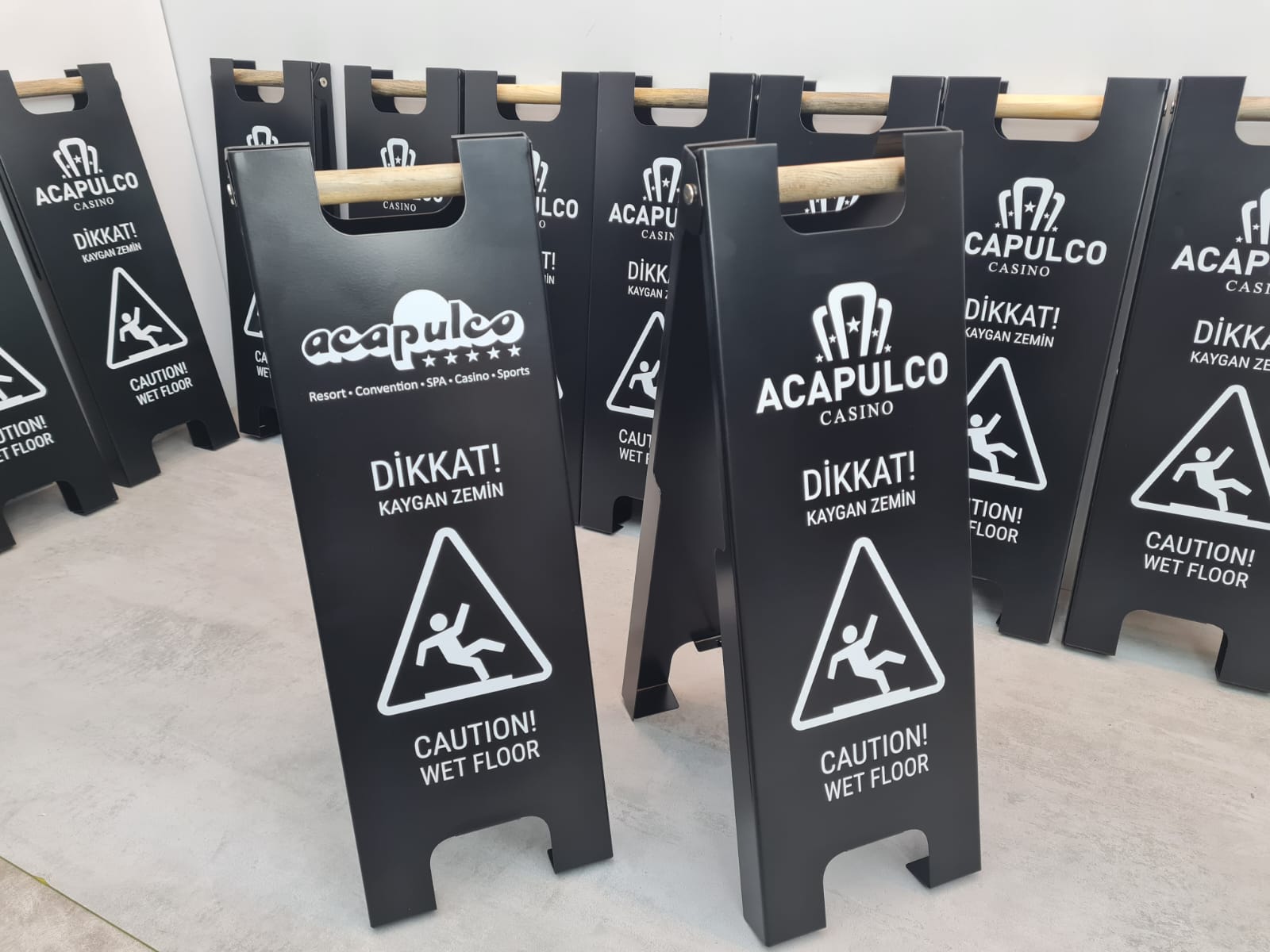 Çift yönlü kullanıma uygun kaygan zemin uyarı tabelası bitkili bir ortamda konumlandırılmış.