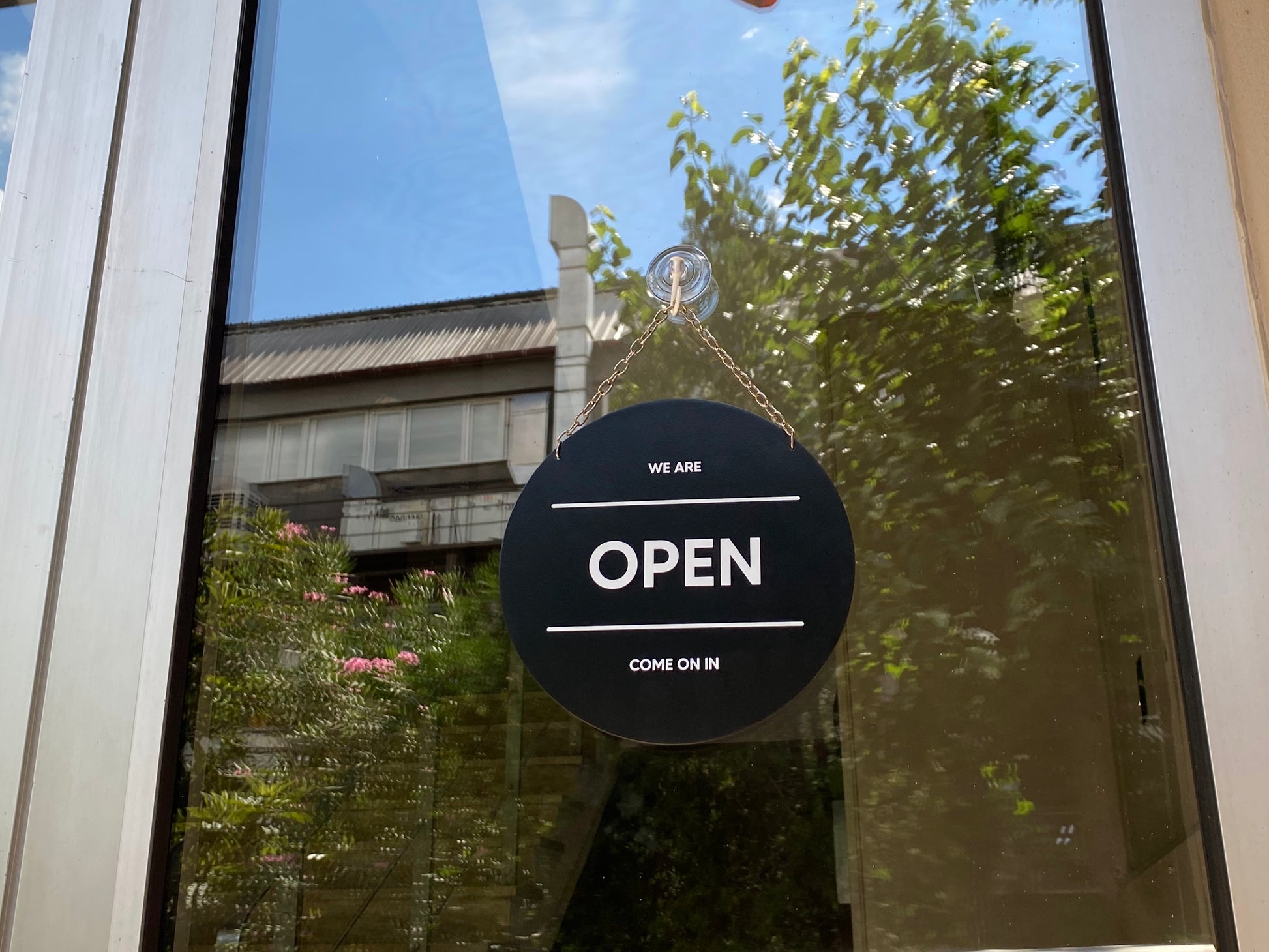 Mağaza kapısına zincirle asılmış açık kapalı metal levha